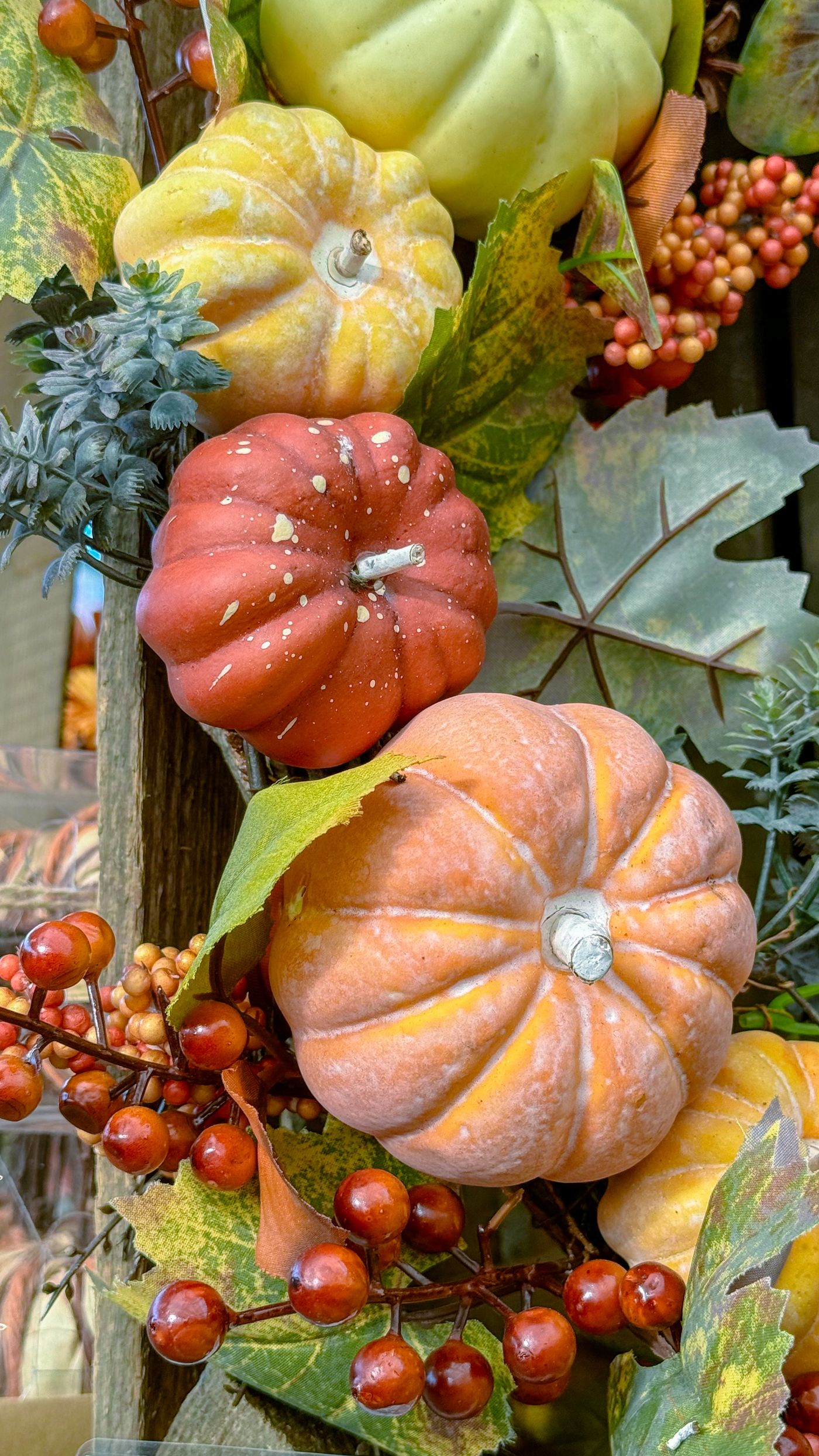 Pumpkins, gourds and autumn leaves fill a seasonal display.