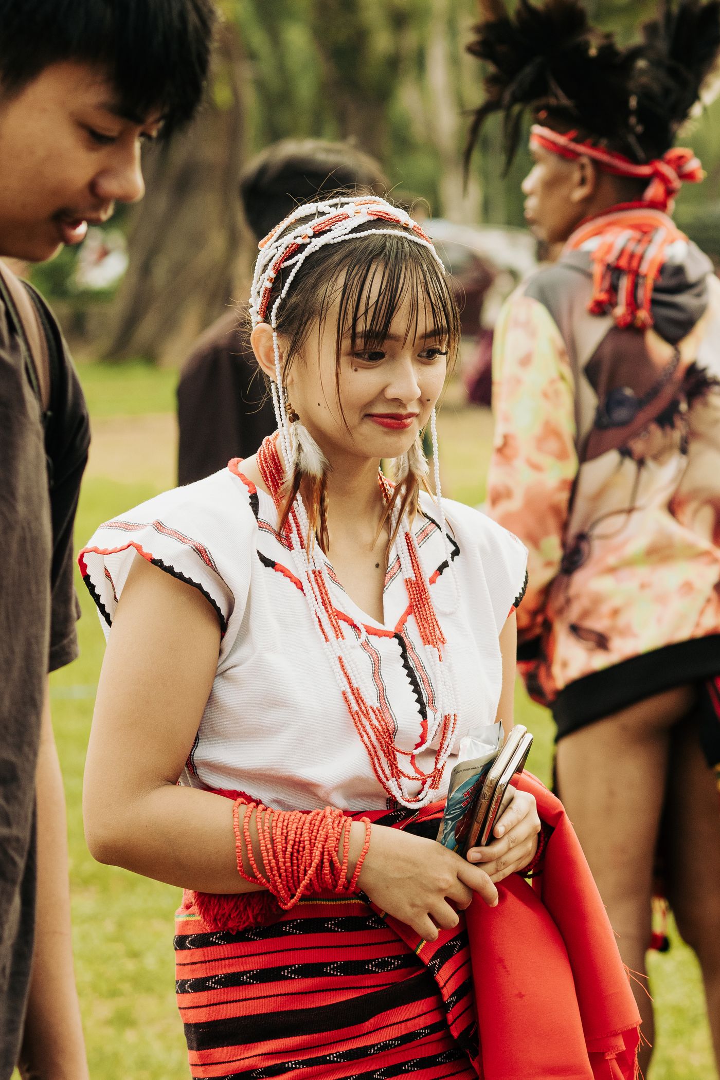 People wear traditional clothing during an outdoor cultural celebration.
