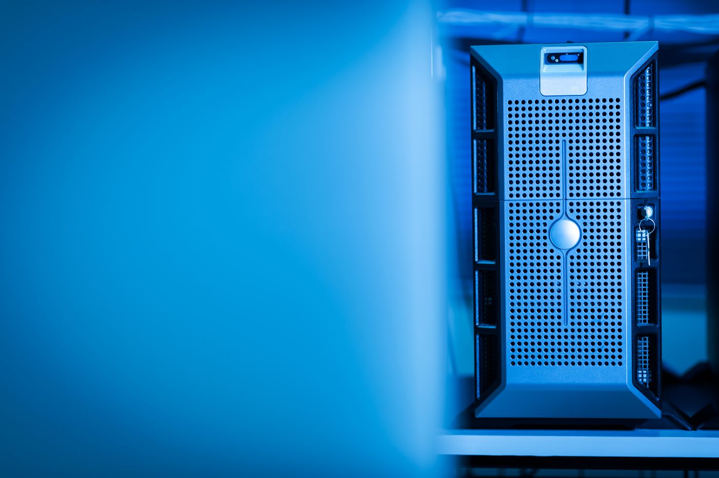 A server unit glows blue inside a data-center room.