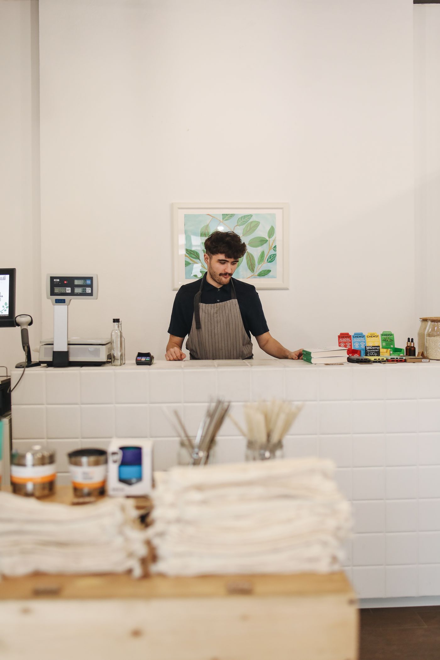 A shop worker stands behind a small-business counter.