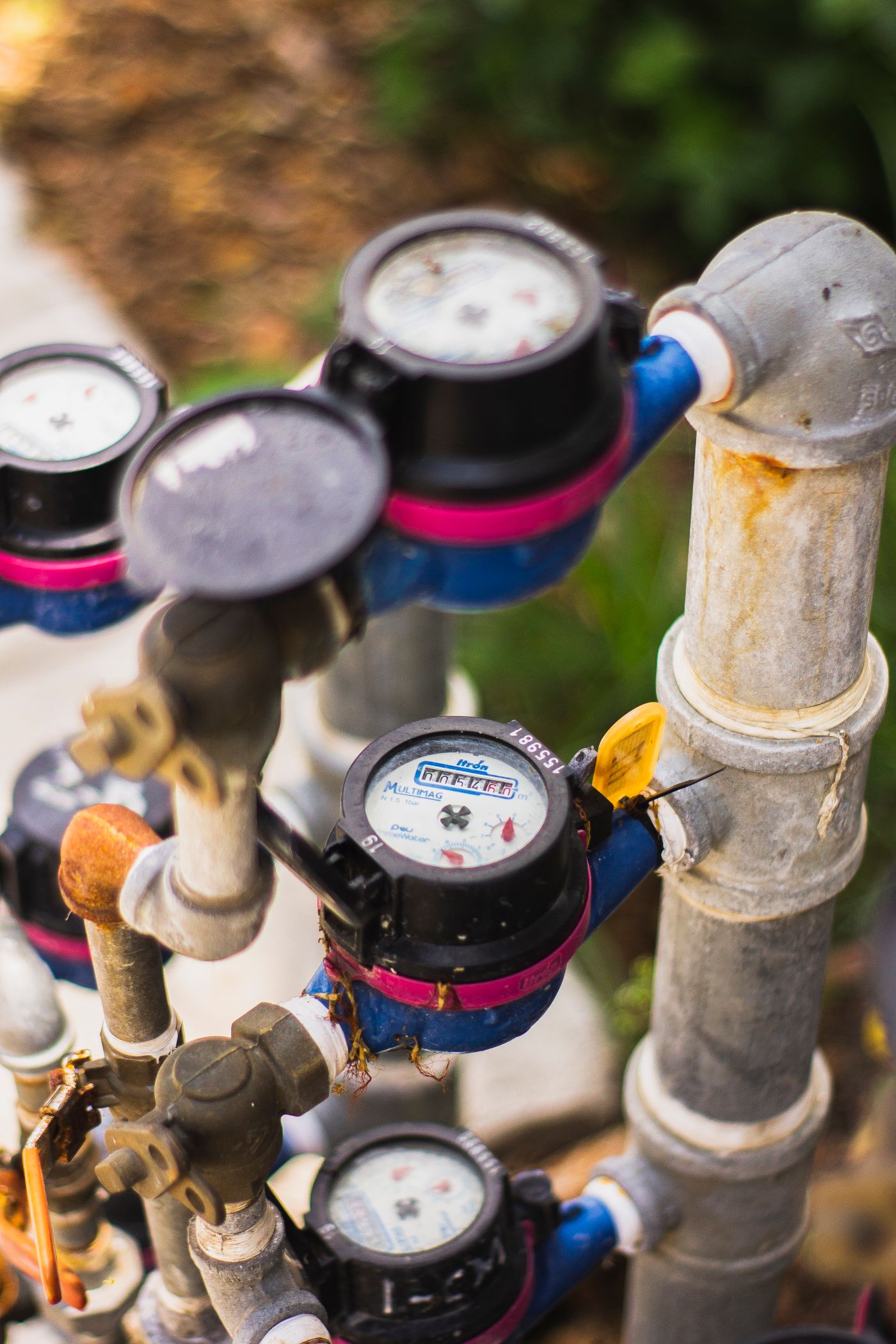 A close view shows a water meter and connected pipes.