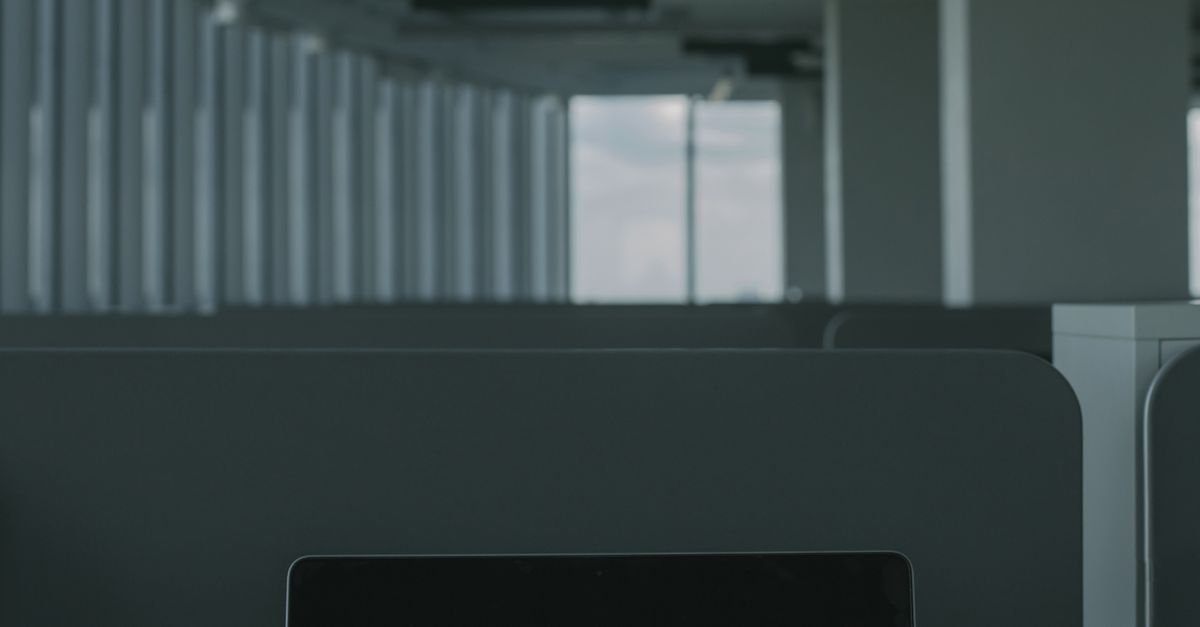 A laptop displays a cybersecurity screen in a dark room.