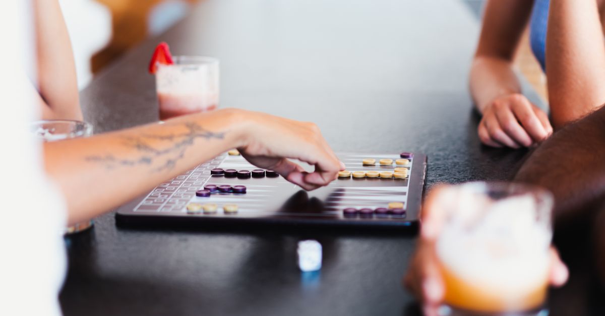 Friends play a tabletop dice game together.
